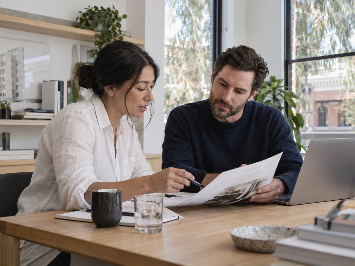 Illustrative scene of two colleagues reviewing a document in a sunlit Australian office.