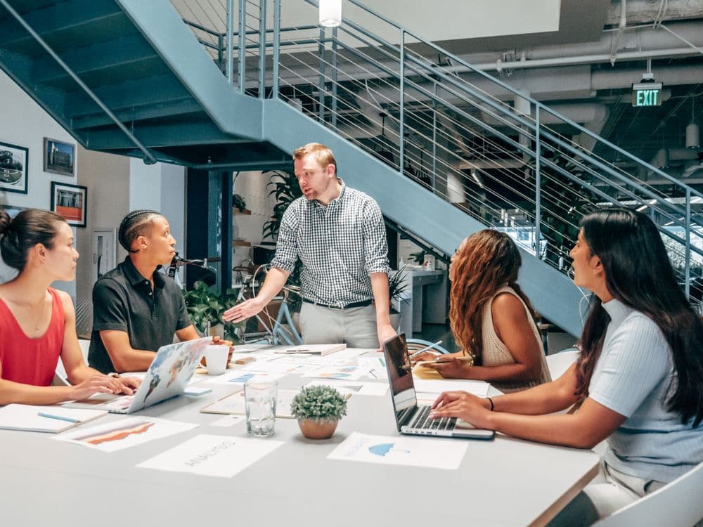 Colleagues sharing ideas around a table in a bright office.